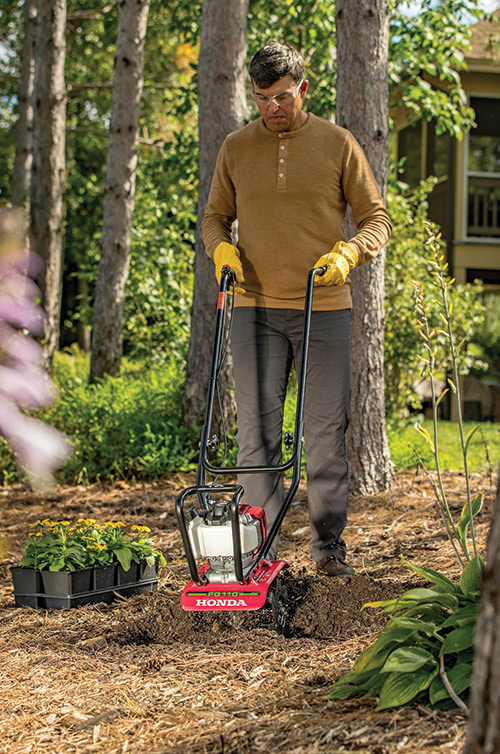 Man tilling dirt with a Honda FG110 Tiller