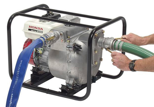 Man tightening a Camlock hose on a Honda WT20X Pump 